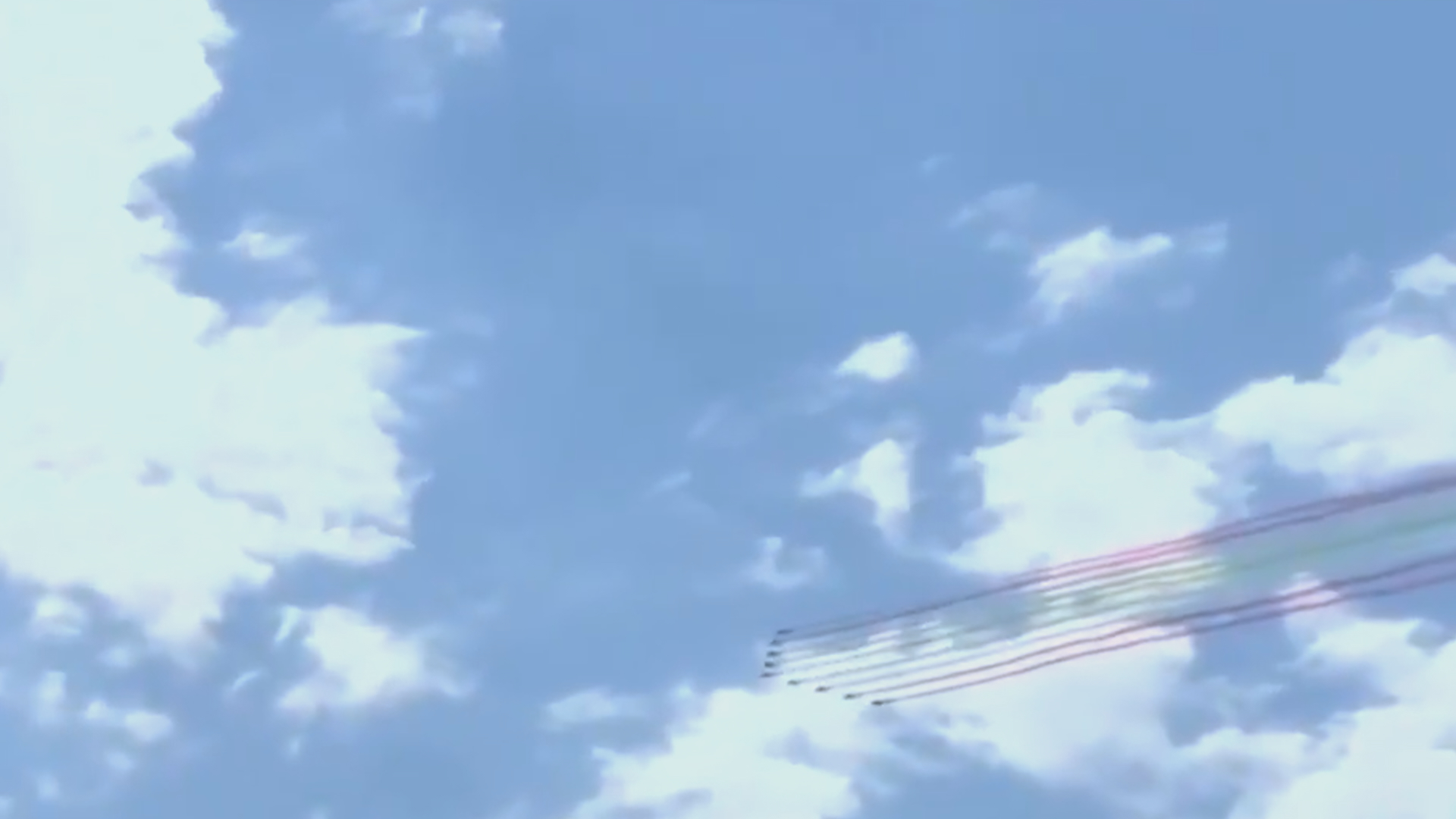 A formation of jets trails vibrant smoke in various colors across a bright blue sky dotted with fluffy white clouds.